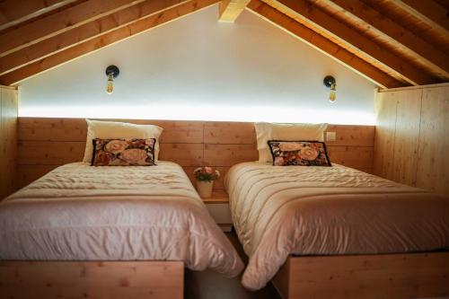 two twin beds in a room with wooden walls at Casa de Campo Gracinda in Tourém