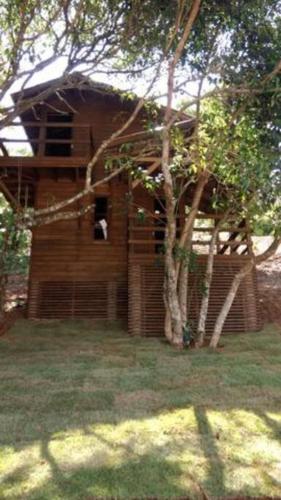 a small wooden building with a dog in a window at Pousada Farol do Arvoredo in Governador Celso Ramos