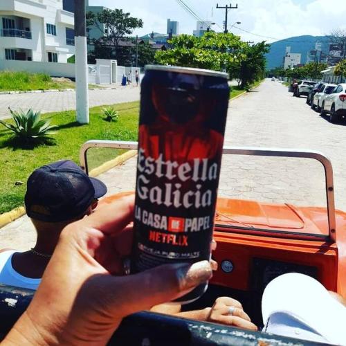 a person holding a cup of coffee in front of a truck at Pousada Farol do Arvoredo in Governador Celso Ramos