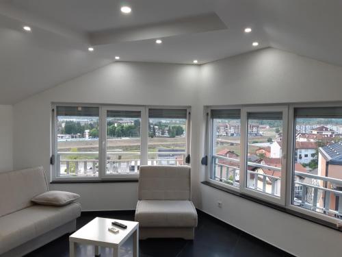 a living room with windows and a couch and a table at apartman Dani in Derventa