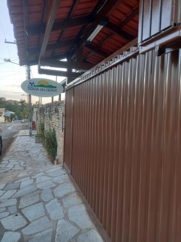 a fence next to a building with a sign on it at Brisa da Serra Hotel Pousada Pirenopolis in Pirenópolis
