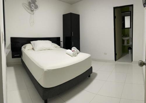a white bed in a white room with a mirror at Hotel Boutique La Riviera in Rivera