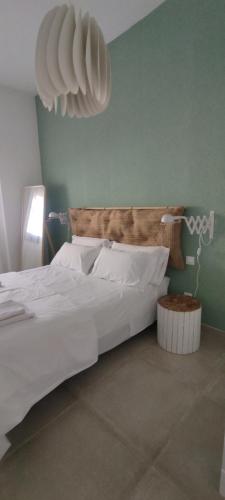 Un dormitorio con una cama grande con sábanas y almohadas blancas. en Mosaiko Apartments II, en Tarifa