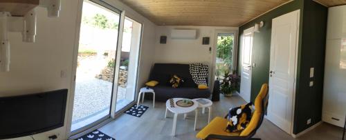 un petit salon avec un canapé et une table dans l'établissement Campagne et Jacuzzi ... c'est cosy le Bumble Bee !, à Panossas