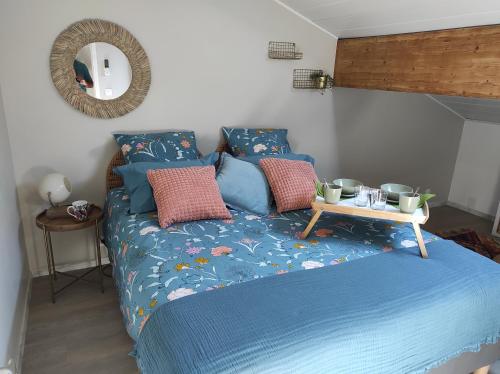 ein Bett mit blauer Bettdecke und einem Tisch darauf in der Unterkunft Campagne et Jacuzzi ... c'est cosy le Bumble Bee ! in Panossas