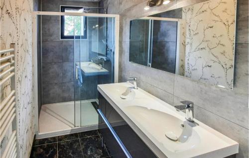 ein Badezimmer mit zwei Waschbecken und einer Glasdusche in der Unterkunft Gorgeous Home In Bacilly With Kitchen in Bacilly