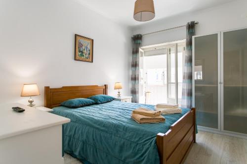 a bedroom with a bed with blue sheets and blue pillows at Isabel Dream IV, 400m from the train in Mem Martins