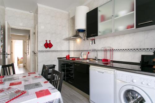 a kitchen with a washing machine and a table at Isabel Dream IV, 400m from the train in Mem Martins