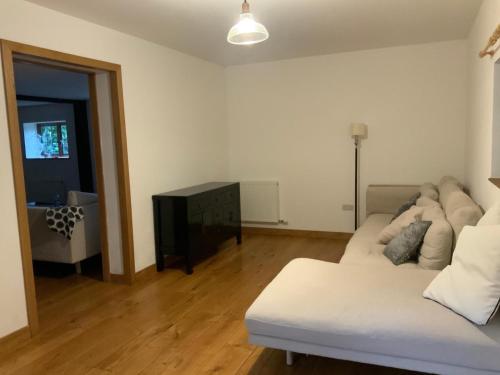 een woonkamer met een witte bank en een tafel bij Delightful 4BD Home full of Flair Edenbridge Kent in Edenbridge