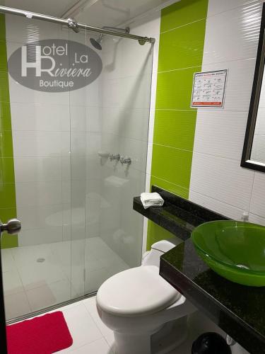 a bathroom with a toilet and a green sink at Hotel Boutique La Riviera in Rivera