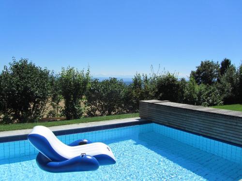 a swimming pool with a lounge chair in it at B&B Pension Marina in Rüttenen  