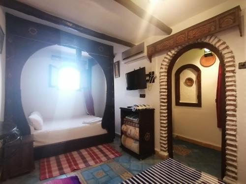 Zimmer mit einem Zimmer mit einem Bett und einem Fenster in der Unterkunft Dar naya in Chefchaouen