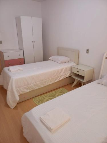 a bedroom with two beds and a mirror at Serra Gaúcha Uva e Vinho 102 in Bento Gonçalves