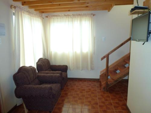 a living room with a couch and a chair and a television at Casa Ananda in Punta de Choros