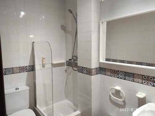 uma casa de banho com um chuveiro, um WC e um lavatório. em Quinta de Carvalhal - Casa de Campo em Guimarães