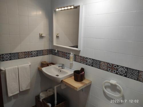 a bathroom with a sink and a mirror at Quinta de Carvalhal - Casa de Campo in Guimarães