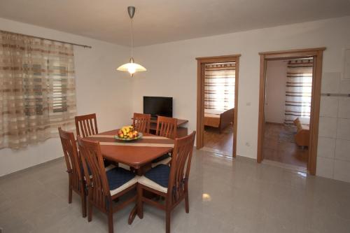 a dining room with a table and chairs and a television at Villa Libana in Povlja