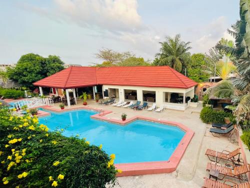 un complejo con piscina y techo rojo en Bamboo Garden Hotel, en Serekunda