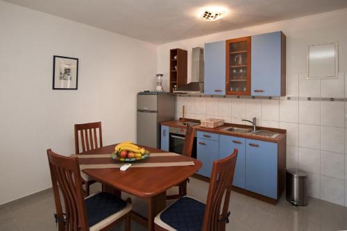 a kitchen with a table with a bowl of fruit on it at Villa Libana in Povlja