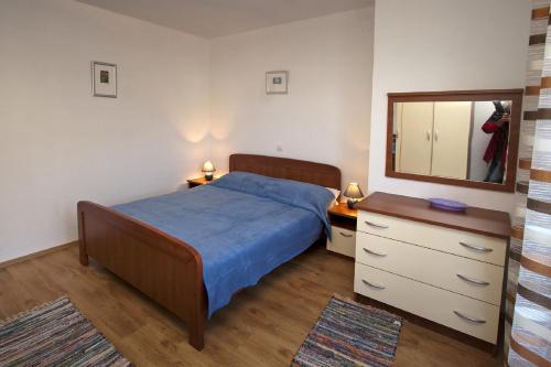 a bedroom with a bed and a mirror and a dresser at Villa Libana in Povlja