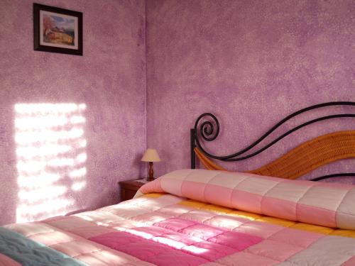 a bedroom with a bed and a purple wall at Lo Scoiattolo in Ventimiglia