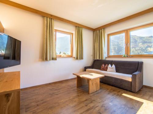 Una sala de estar con un sofá y un televisor. en Blasinghof, en Hainzenberg