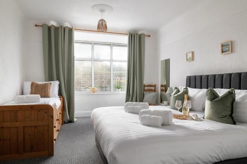 a bedroom with two beds and a window at Beachcliffe House - Sea front property - Sleeps 10 - Pet friendly in Llandrillo-yn-Rhôs