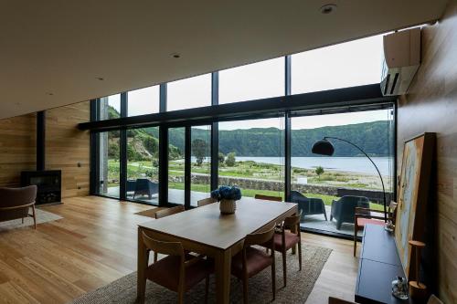 a dining room with a table and chairs and a large window at Sete Cidades Lake Cabin - Casa da Lagoa in Ponta Delgada