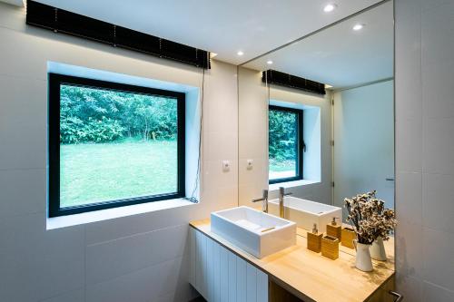 a bathroom with a sink and a large window at Sete Cidades Lake Cabin - Casa da Lagoa in Ponta Delgada