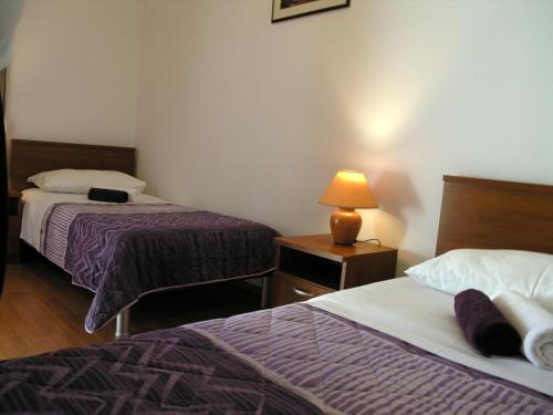 una habitación de hotel con 2 camas y una lámpara en una mesa en Apartments by the sea Businci, Ciovo - 4863, en Trogir