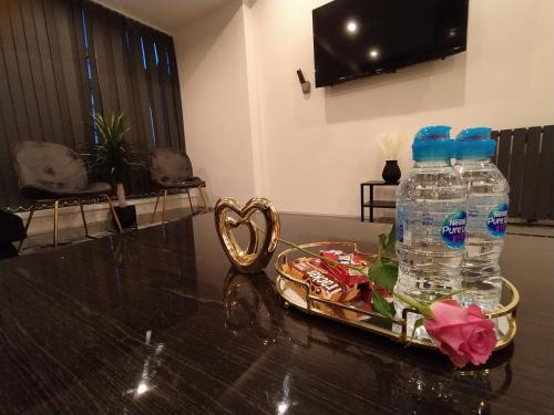 - une table avec 2 bouteilles d'eau et un plateau de nourriture dans l'établissement Black Pearl Luxury Apartments, à Blackpool