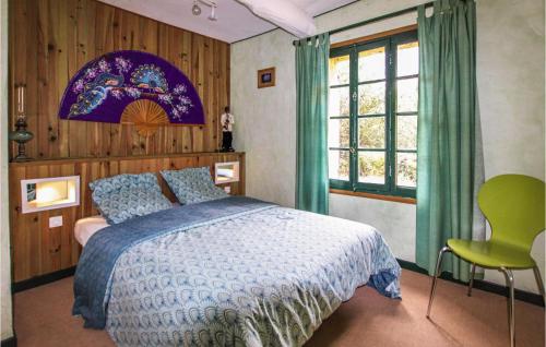 ein Schlafzimmer mit einem Bett mit blauer Decke und einem Fenster in der Unterkunft Cozy Home In Entrechaux With Private Swimming Pool, Can Be Inside Or Outside in Entrechaux