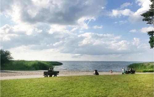 a group of people sitting on a beach near the water at Holiday Home Bellin 59 in Bellin