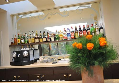 a bar with a mirror with a bunch of bottles at Hotel de L'Universite in Paris