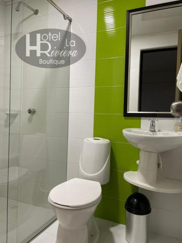 a bathroom with a toilet and a sink and a mirror at Hotel Boutique La Riviera in Rivera