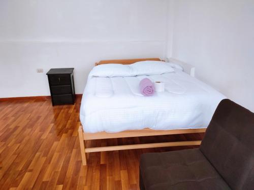 a bedroom with a bed with a pillow and a chair at ENEDE HOSTEL in Cusco