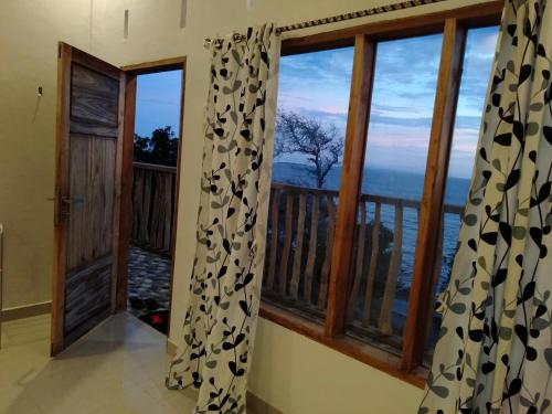 a room with a view of a balcony with windows at Bara Village Guest House Bira in Bira