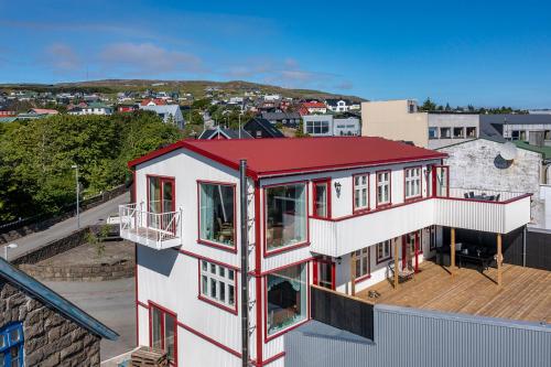 a red and white house with a red roof at Downtown - Retro Decor - Stunning Views - Terrace in Tórshavn
