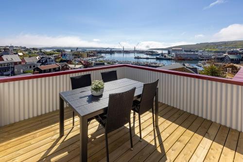 ein Tisch und Stühle auf einem Balkon mit Blick auf einen Hafen in der Unterkunft Downtown - Retro Decor - Stunning Views - Terrace in Tórshavn