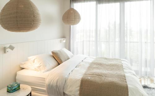 sypialnia z łóżkiem i dużym oknem w obiekcie Aquabelle Apartments w mieście Rye