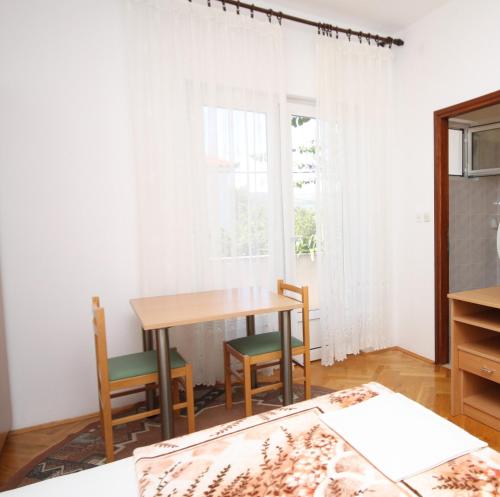 a dining room with a table and chairs and a window at Apartments and rooms by the sea Seline, Paklenica - 6440 in Starigrad-Paklenica