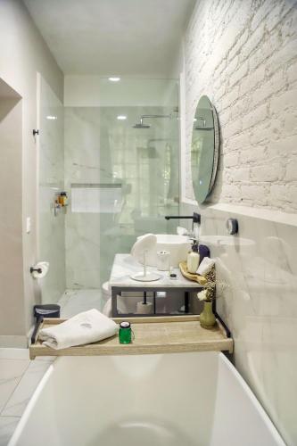 a bathroom with a tub and a sink and a mirror at Agata Hotel Boutique & Spa in Mexico City