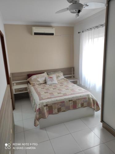 a bedroom with a bed and a window at APARTAMENTO DE PRAIA in Florianópolis