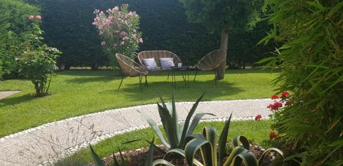 a garden with two chairs and a table in the grass at Casa Lola in Cavallino-Treporti
