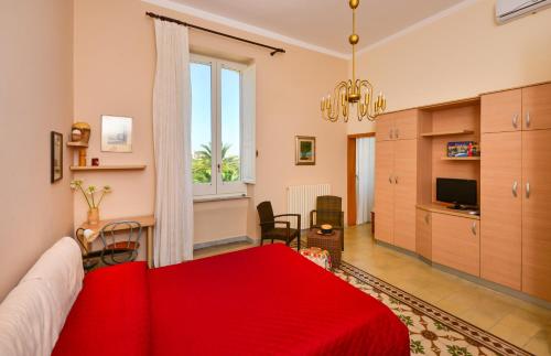 a bedroom with a red bed and a living room at Balcone su Otranto in Otranto