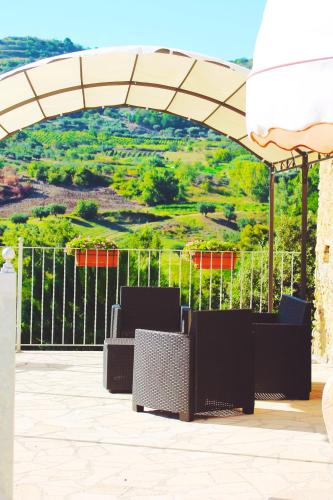 a patio with a table and chairs under an umbrella at Agriturismo U' Casinu dà Scala in Campora San Giovanni