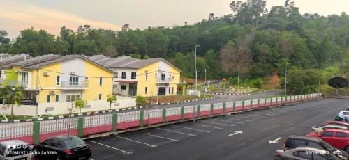 a train traveling down a road next to houses at D'Zara Homestay in Sepang