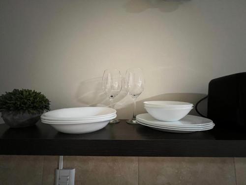 two white bowls and wine glasses on a table at 9 de Julio Apart in Concepción del Uruguay