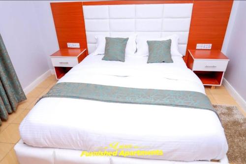 MeruにあるLuxe Furnished Apartmentsのベッドルーム1室(白い大型ベッド1台、ナイトスタンド2台付)