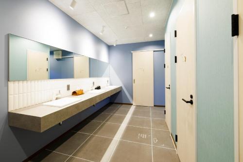 a bathroom with two sinks and a large mirror at the circle apartment in Shima